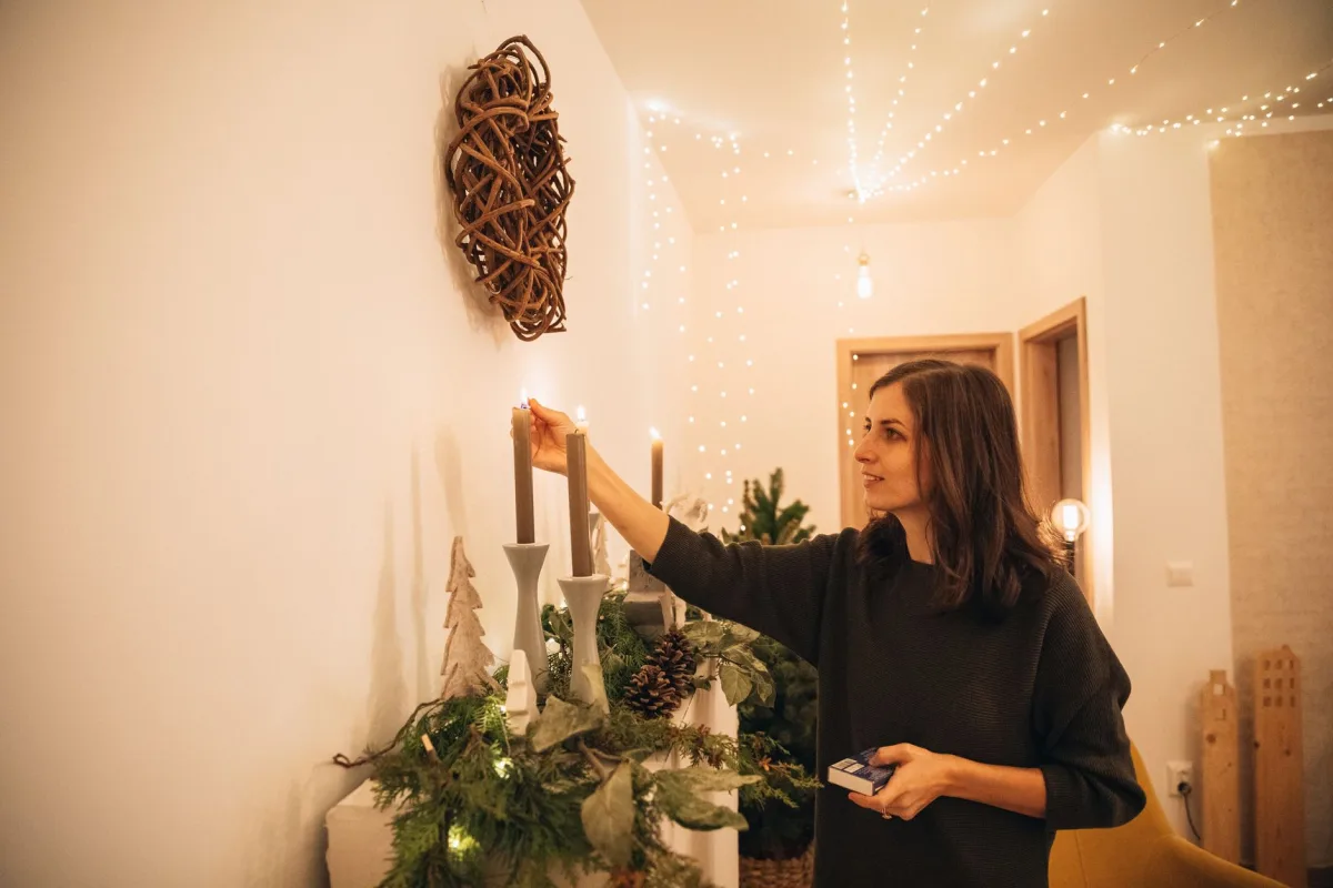 Ambiance éclairage cosy chaleureux avec bougies et guirlandes lumineuses dans un salon
