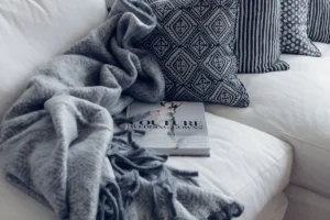 Superposition de plaids, coussins et tapis en textiles automnaux chaleureux