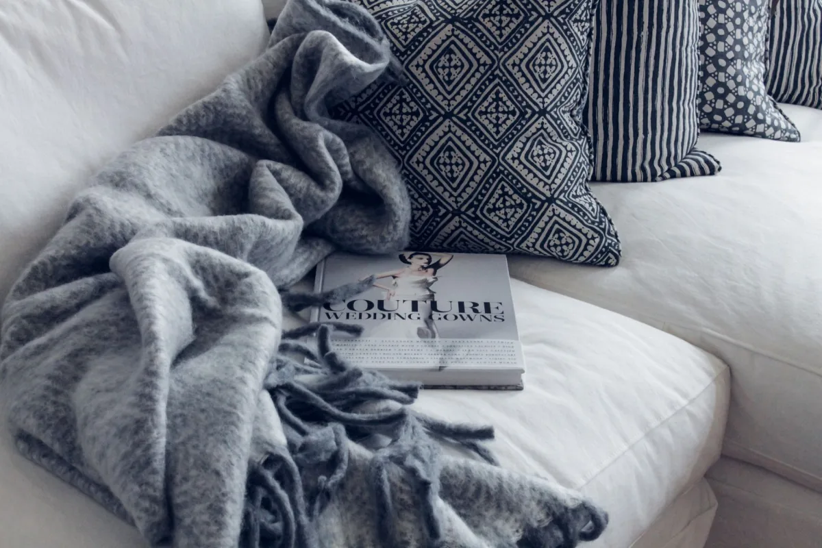 Superposition de plaids, coussins et tapis en textiles automnaux chaleureux